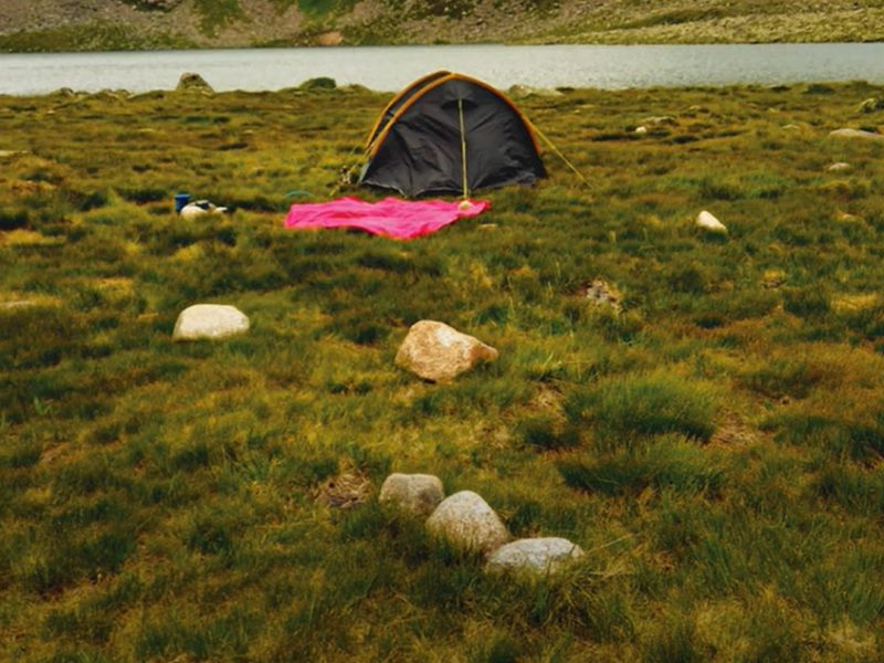 A tent and tablecloth set up in the countryside