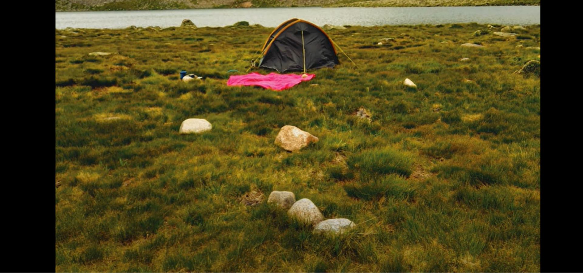 A tent and tablecloth set up in the countryside