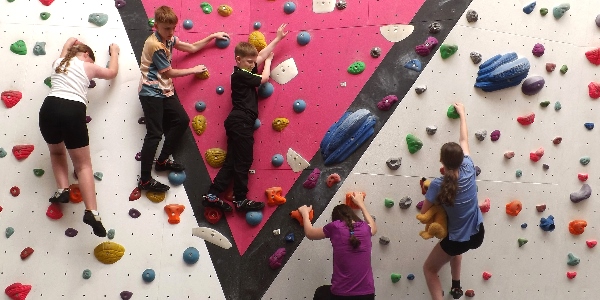 A group of children enjoying a climb on the bouldering wall