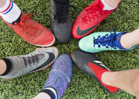 A circle of trainers on a grass pitch