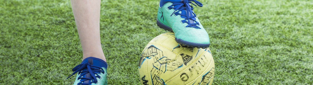 A child's foot on a football
