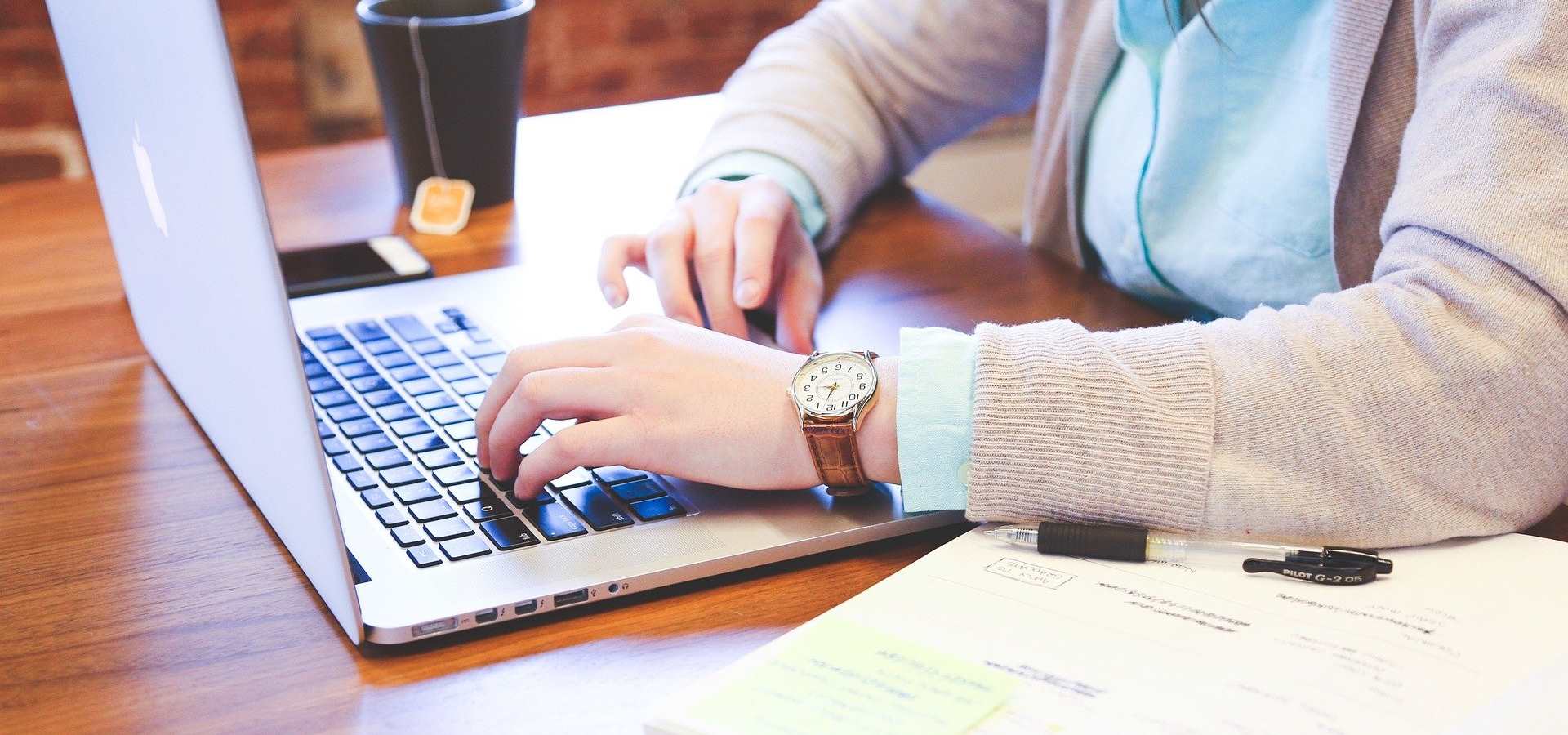 A person sitting at a desk on a laptop