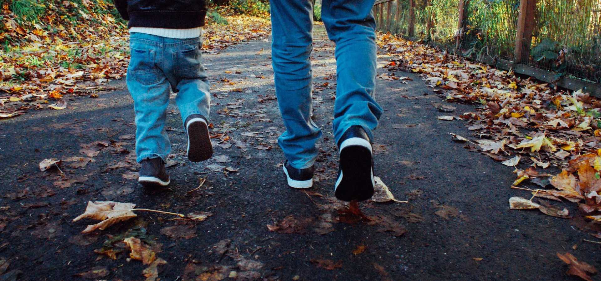 An adult and child enjoying a walk through the forest