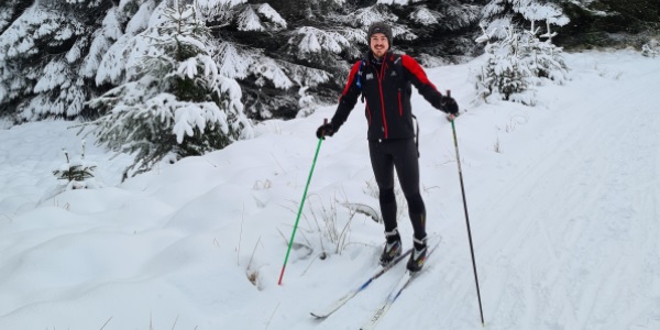 A man skiing in heavy snow in the forrest